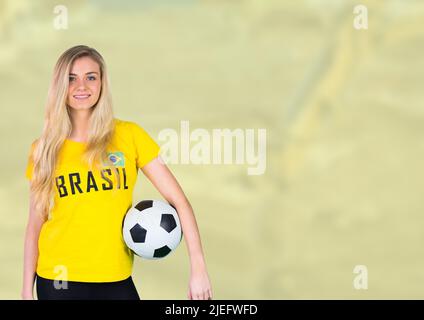 Image composite d'une femme caucasienne tenant le ballon de football sur un arrière-plan flou avec un espace de copie Banque D'Images