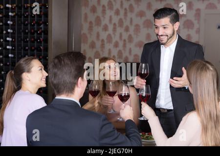 Un homme heureux prononçant des toasts dans un restaurant confortable Banque D'Images