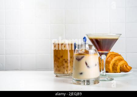 Ensemble de trois boissons au café dans différents verres de cocktails, sur fond blanc espace copie Banque D'Images