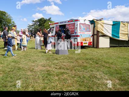 Des gens qui font la queue pour des glaces dans une camionnette dans un parc Banque D'Images