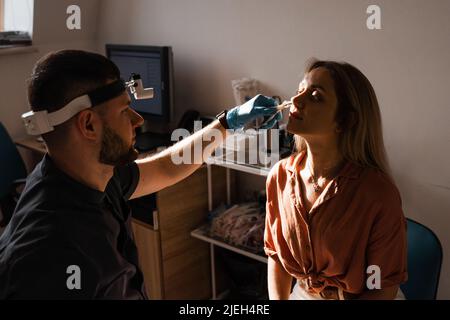 Rhinoscopie du nez de la femme. Consultation avec le médecin. L'otolaryngologiste examine le nez de la jeune fille avant la procédure d'endoscopie du nez Banque D'Images