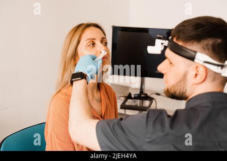 Rhinoscopie du nez de la femme. Consultation avec le médecin. L'otolaryngologiste examine le nez de la jeune fille avant la procédure d'endoscopie du nez Banque D'Images