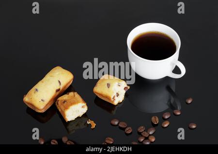 Barres à gâteau aux pépites de chocolat et tasse de café sur fond noir Banque D'Images