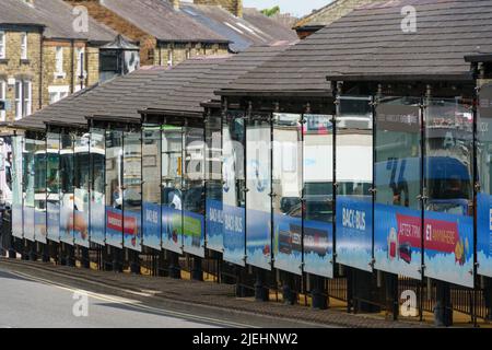 Un long abri de bus près de la gare routière de Harrogate avec panneaux de verre réfléchissants, Harrogate, North Yorkshire, Angleterre, Royaume-Uni. Banque D'Images