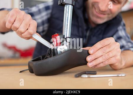 Jeune homme réparer un vélo avec ses outils Banque D'Images