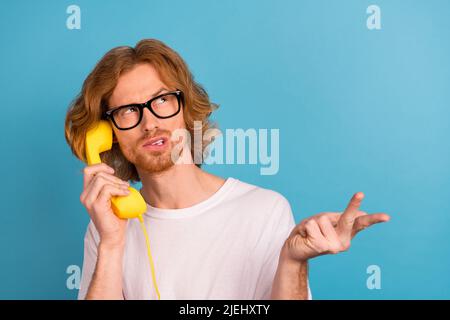 Portrait d'esprit sérieux personne bras tenir parler vintage téléphone comptant contempler isolé sur fond bleu de couleur Banque D'Images