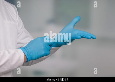 Gros plan des mains portant des gants médicaux Banque D'Images