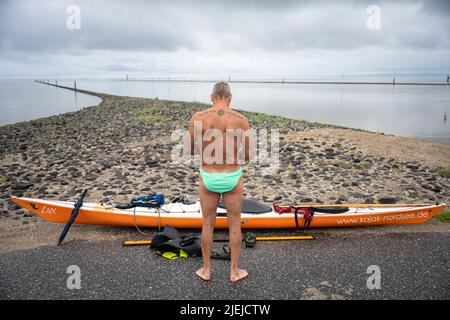 Greetsiel, Allemagne. 27th juin 2022. Frank Feldhus se prépare à nager dans la baie de Ley, en frison oriental. Il nagé dans sept îles et de retour dans sept jours. L'Oldenburger veut attirer l'attention sur la pollution des mers avec son action. Il nagez de la baie à Borkum. Les jours suivants, il nagera de Juist, Norderney, Baltrum, Langeoog, Spiekeroog et Wangerooge vers le continent. Au total, il couvrira 66 kilomètres. Credit: Mohssen Assanimoghaddam/dpa/Alay Live News Banque D'Images