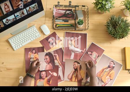 Vue en grand angle de l'éditeur de photos examinant les photos professionnelles retouchées à la table Banque D'Images