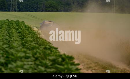 Ebstorf, Allemagne. 27th juin 2022. Un agriculteur conduit sa voiture le long d'une route poussiéreuse. Credit: Philipp Schulze/dpa/Alamy Live News Banque D'Images