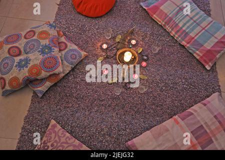 Set de cacao cru avec des fleurs bougies, plumes, Palo Santo, feuilles de baie, et oreillers pour la cérémonie chamanique Banque D'Images