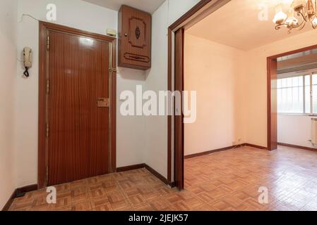 Hall d'entrée d'une maison résidentielle avec parquet en sol sintasol, accès à une chambre vide avec une grande fenêtre Banque D'Images