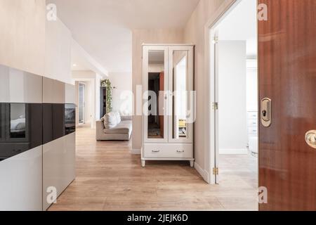 Hall d'entrée d'une maison avec armoires blanches et portes-miroirs, couloir et accès à plusieurs pièces Banque D'Images