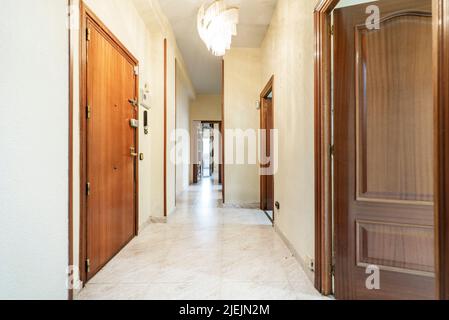 Couloir de distribution d'une maison avec portes en bois sombre et carrelage en céramique Banque D'Images