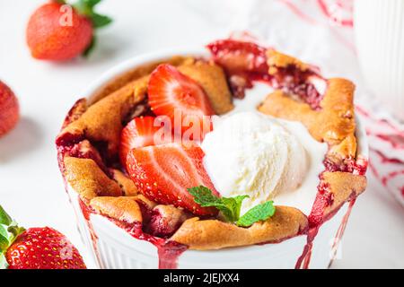 Tarte aux fraises et à la crème glacée dans un plat blanc. Recette de dessert aux fruits d'été. Banque D'Images