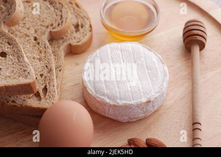 fromages frais, miel, œuf et pain sur une assiette Banque D'Images