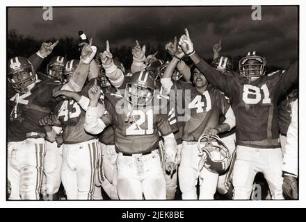 Joueurs de football de. John the Baptist High School a célébré sa victoire au Metro Bowl en 1982. Les champions de la Catholic High Schools Football League se sont enfuis avec le titre pour la troisième année consécutive en battant John Adams, le champion de la public Schools Athletic League, 27-16, à Midwood Field à Brooklyn. Banque D'Images