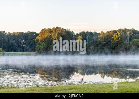 Piscine, ville de Géorgie près de Savannah avec lever du soleil le matin lumière du soleil vue sur le paysage à un étang de lac avec brouillard de brume montante de la vapeur d'eau la nuit froide et Banque D'Images