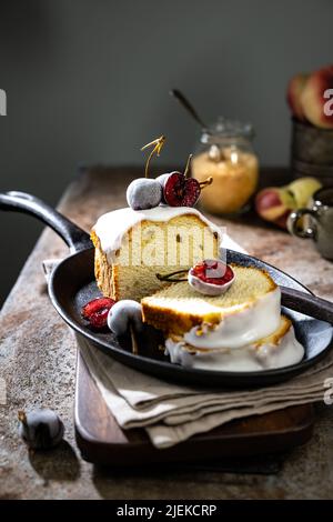 Gâteau rafraîchissant au citron recouvert de glaçage et décoré de cerises glacées.délicieux dessert Banque D'Images