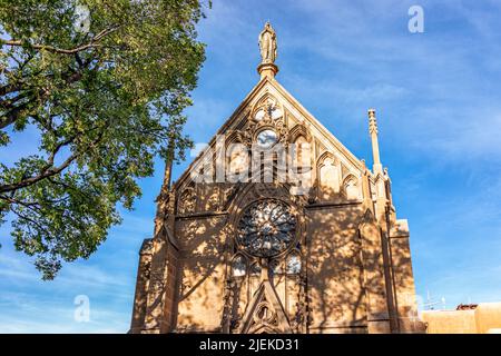 La vieille église historique de la chapelle Loretto à Santa Fe, Nouveau-Mexique, aux États-Unis, avec une façade extérieure et une ombre d'arbre le jour ensoleillé contre b Banque D'Images