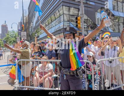 NEW YORK, New York – 26 juin 2022 : un policier de la ville de New York est vu avec des spectateurs lors de la Marche de la fierté de New York en 2022 à Manhattan. Banque D'Images