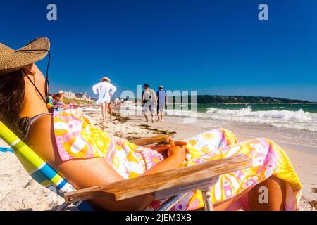 Une femme qui fait une sieste sur la plage Banque D'Images