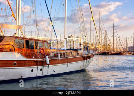 Groupe de bateaux amarrés dans un port de Bodrum en Turquie au coucher du soleil. Vue panoramique sur les yachts à voile dans le port de croisière et la baie au crépuscule. Vider le chantier naval dans Banque D'Images