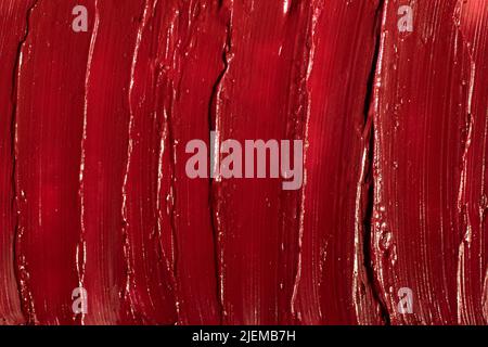 Rouge abstrait taches de rouge à lèvres brillant, macro photographie de texture. Banque D'Images