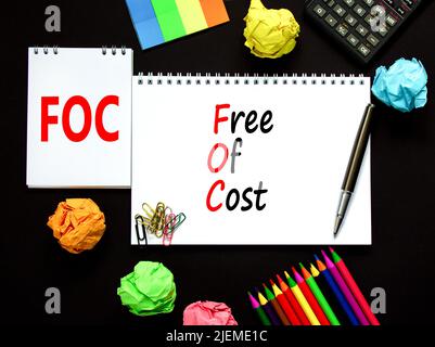 Symbole gratuit FOC. Concept mots FOC gratuit sur note blanche sur un beau fond noir. Calculatrice et stylo. Business et FOC sans co Banque D'Images