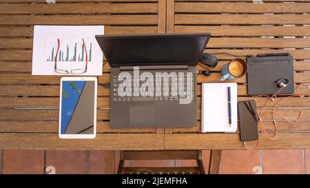 Télétravail à la maison depuis le jardin avec ordinateur portable et autres gadgets. Vue aérienne. Banque D'Images