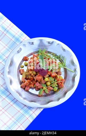 fermer les pois frits, le chou-fleur, la carotte rouge, avec la menthe et la fleur sauvage sous les légumes faits dans la plaque d'acier avec un tissu sur le dos bleu de foyer Banque D'Images