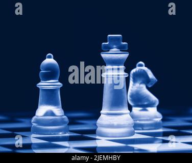 Échecs de verre sur le plateau d'échecs. Photographié de près avec l'arrière-plan noir Banque D'Images
