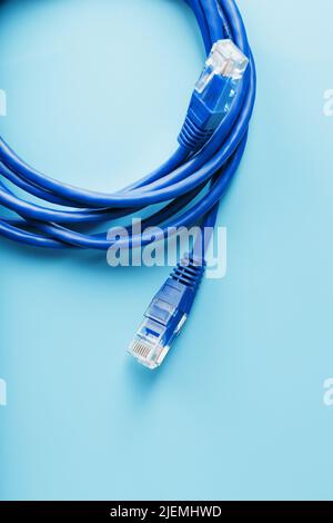Une bobine de câble réseau Internet Ethernet RJ45 de catégorie 6 isolée sur fond bleu avec de l'espace libre Banque D'Images