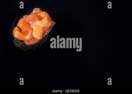 Sushi de saumon tartare gunkan maki avec saumon frais cru avec espace de copie sur fond noir Banque D'Images