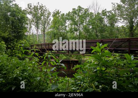 Le vieux pont en bois se dresse au-dessus de la rivière qui coule doucement Banque D'Images