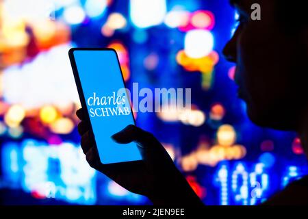 Brésil. 27th juin 2022. Dans cette illustration, une femme silhouetée tient un smartphone avec le logo Charles Schwab Corporation affiché à l'écran. (Credit image: © Rafael Henrique/SOPA Images via ZUMA Press Wire) Banque D'Images