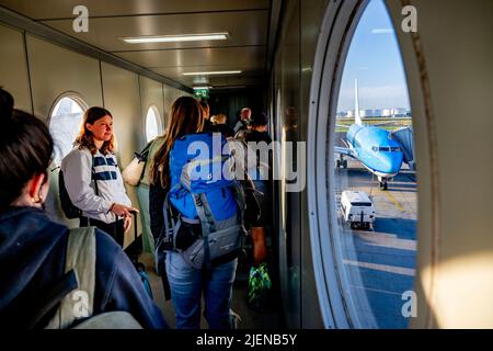 Schiphol, pays-Bas. 26th juin 2022. Une longue file de voyageurs est vue marcher à travers un pont à réaction, sur leur chemin pour prendre le vol de l'aéroport de Schiphol. L'aéroport avertit maintenant sans équivoque qu'il pourrait y avoir des heures de files d'attente dans les semaines à venir. Au cours de la période à venir, il sera aussi occupé que pendant les vacances de mai. KLM met un frein à la vente de billets pour les vols qui partiront de Schiphol dans les jours à venir. Crédit : SOPA Images Limited/Alamy Live News Banque D'Images