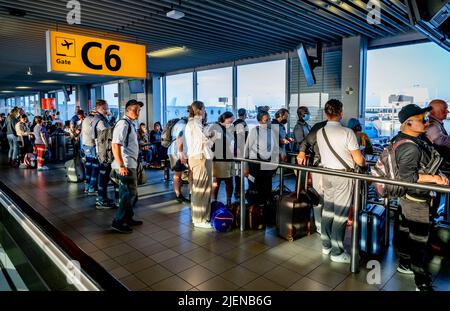 Schiphol, pays-Bas. 26th juin 2022. Les voyageurs attendent dans les couloirs de départ pour prendre leur vol depuis l'aéroport de Schiphol. L'aéroport avertit maintenant sans équivoque qu'il pourrait y avoir des heures de files d'attente dans les semaines à venir. Au cours de la période à venir, il sera aussi occupé que pendant les vacances de mai. KLM met un frein à la vente de billets pour les vols qui partiront de Schiphol dans les jours à venir. Crédit : SOPA Images Limited/Alamy Live News Banque D'Images