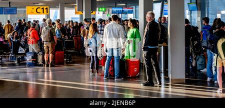 Schiphol, pays-Bas. 26th juin 2022. Les voyageurs attendent dans les couloirs de départ pour prendre leur vol depuis l'aéroport de Schiphol. L'aéroport avertit maintenant sans équivoque qu'il pourrait y avoir des heures de files d'attente dans les semaines à venir. Au cours de la période à venir, il sera aussi occupé que pendant les vacances de mai. KLM met un frein à la vente de billets pour les vols qui partiront de Schiphol dans les jours à venir. Crédit : SOPA Images Limited/Alamy Live News Banque D'Images