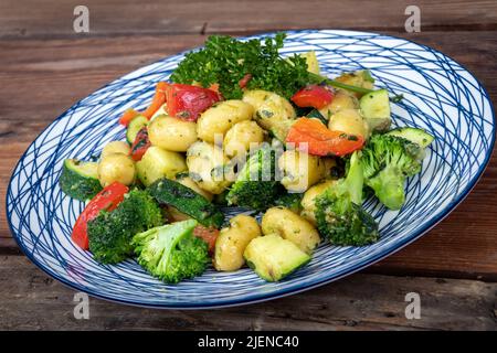 Pâtes gnocci aux herbes et au fromage avec plat de légumes sur la table Banque D'Images