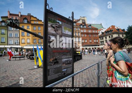 Les femmes lisent des informations sur les équipements militaires russes détruits dans le centre de Varsovie. L'exposition d'équipements russes détruits pendant la guerre en Ukraine s'ouvre sur la place du Château, au centre de Varsovie. Varsovie est devenue la première capitale européenne à inviter l'exposition organisée par la Chancellerie du Premier ministre de la partie polonaise et le Ministère de la défense de l'Ukraine de la partie ukrainienne. Les visiteurs peuvent voir le char T-72-B et le système d'artillerie automoteur Howitzer 2S19 Msta-S ainsi que des échantillons de coquillages. (Photo de Volha Shukaila/SOPA Images/Sipa USA) Banque D'Images