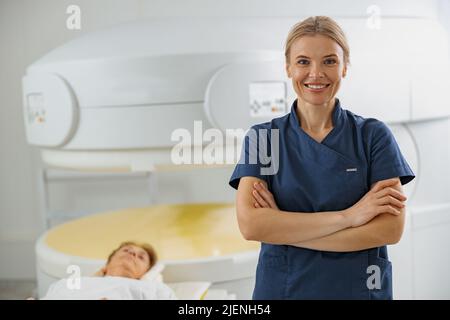 Portrait d'un médecin radiologue en arrière-plan de l'IRM ou de l'acquisition CT avec le patient en cours de procédure Banque D'Images