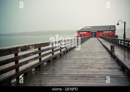 Vue depuis Coupeville Washington sur l'île Whidbey avec jetée et bâtiment historique en vue, par temps de pluie Banque D'Images