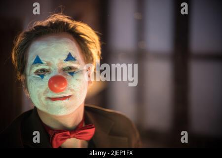 Clown concept - un homme avec clown peint visage souriant Banque D'Images