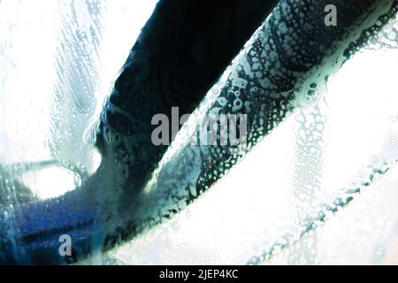 du savon et de l'eau qui coule sur le pare-brise d'une voiture dans un lave-auto Banque D'Images