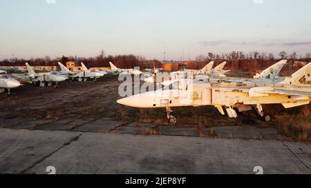 Vol avec vue sur les drones aériens au-dessus du stationnement de nombreux anciens avions démantelés. Cimetière d'avions cassés s'est écrasé avion à l'aube du coucher du soleil. Gros plan vue de dessus abandonné avion, ancien avion de chasse militaire Banque D'Images