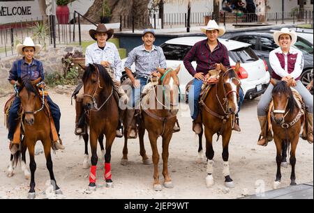 Chapala, Jalisco, Mexique - 10 mai 2021: Cinq Charros mexicains fiers posant sur des chevaux avec un sourire. Cow-boys traditionnels du Mexique debout dans une rangée Banque D'Images