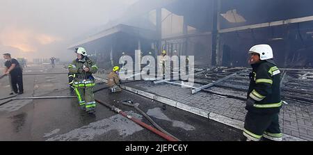 Kremenchuk, Ukraine. 27th juin 2022. Les pompiers travaillent pour mettre le feu dans un centre commercial frappé par une frappe de missiles russes à 3 h 50 un lundi après-midi, dans la ville ukrainienne orientale de Kremenchuk. Les responsables ukrainiens affirment que plus de 1 000 civils se trouvaient à l'intérieur au moment de l'attaque et que 18 civils innocents ont été tués et des dizaines de blessés après la frappe inattendue de missiles russes. (Image de crédit : © Service d'urgence de l'État ukrainien/ZUMA Press Wire) Banque D'Images