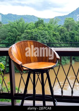 Tabouret rond vide en bois fait par de petites planches en bois et cadre en acier noir près du bar de table extérieur sur la terrasse sur la jungle verte, les montagnes et Banque D'Images