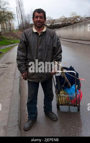 Sofia, Bulgarie. Sad Roma Homme marchant dans les rues du quartier Hristo Botev, le quartier séparé près de Slatina. Les hommes roms sont victimes de discrimination, mènent une vie appauvrie avec leurs familles et vivent dans des maisons de sous-standard, souvent sans eau ni électricité. Banque D'Images